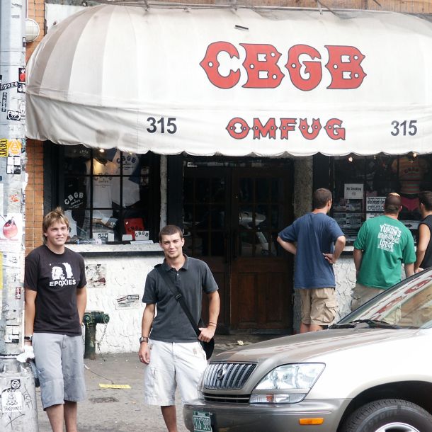 The front of CBGB on the Bowery, young people gathered under the awning. The image holds the early music years — the physical rooms, the culture, and the unglamorous work of keeping the conditions intact so the music could happen.
